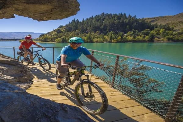 Cyclists riding the Lake Dunstan Cycle Trail beside the lake